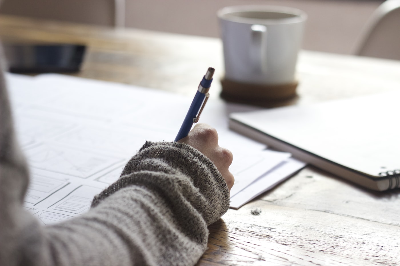 A hand sketching ideas at a desk